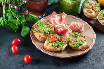 Bruschetta with fresh pesto, mozzarella and cherry tomatoes on a plate