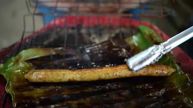 Roasted or Grilled Notrhern Thai Spicy Sausage (Sai Aua) for sale at Thai street food market or restaurant in Thailand