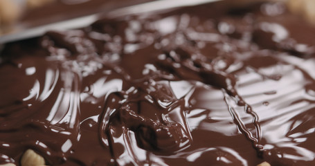 closeup spreading chocolate over roasted cashew