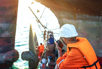 foreman in charge of command in repairing and replacement of shaft on propeller of the ship at medsea port by the workers and technician © ID_Anuphon