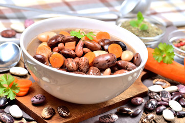 Bean soup with large beans, carrots, parsley, marjoram, spoon and ladle
