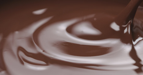 closeup stirring melted dark chocolate with spoon
