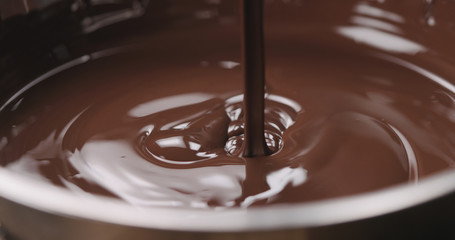 closeup pouring molten dark chocolate