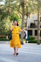 Fototapeta premium Asian girl on the phone with shopping bags