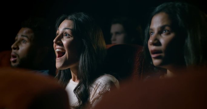 Happy and entertained movie theatre audience enjoying a great movie theatre experience.