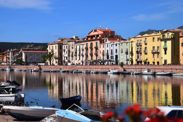 Fototapeta na wymiar mediterranean idyll in bosa, panoramic view on the boats on the river temo in Bosa in Sardinia including typical colorful Italian houses these are reflected in the river
