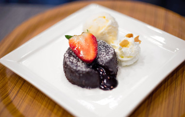 chocolate lava cake with ice cream and cream and strawberries