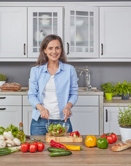 Cheerful woman preparing a salad