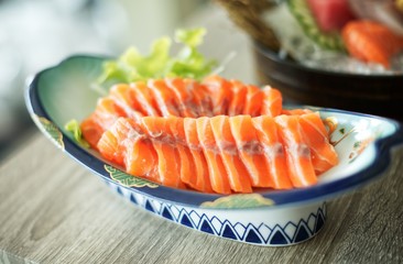 Salmon raw sashimi on white Japanese traditional dish on wooden table : Closed up