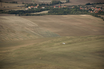 Little airplane viewed from Rana hill in Czech central mountains tourist area at sunrise on 16th September 2018