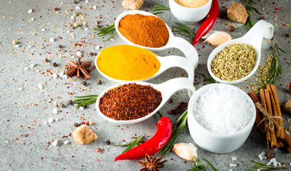 Spices in Wooden spoon. Curry, Saffron, turmeric, rosemary, cinnamon, garlic, pepper, anise on wooden rustic background. Collection of spices and herbs. Salt, paprika. Copy space. Top view. 