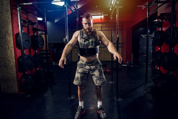 Fototapeta na wymiar Strong focused sporty bodybuilder working out in gym.