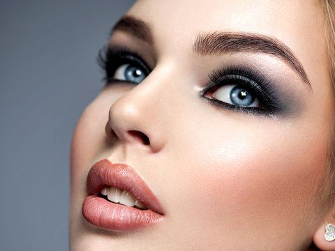 Closeup face of a beautiful girl with  makeup in style smoky eyes.