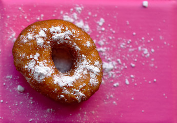 
fried donut covered with powdered sugar

