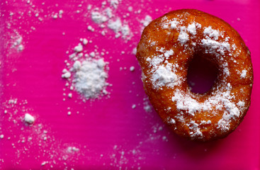 
fried donut covered with powdered sugar

