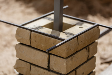 The worker is laying bricks on the fence