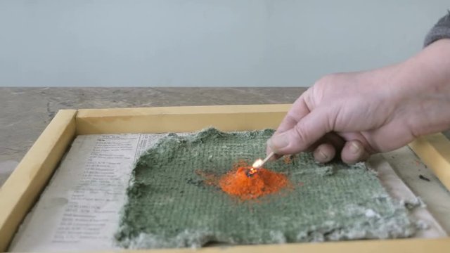 Chemical fire experiment in School lab. Eruption of ammonium dichromate volcano. Slider view
