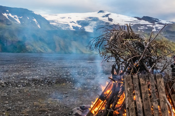 Ritual bonfire during the summer solstice in the midst of the surreal landscapes of ThorsmorkHighlands of Iceland. The Eyjafjallajokull volcano can be seen in the background.