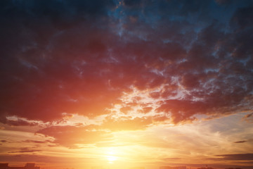 Creative background. Beautiful, atmospheric sunset in the sky. Red, yellow rays of the setting sun. copy space