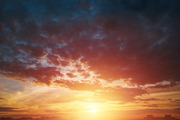 Creative background. Beautiful, atmospheric sunset in the sky. Red, yellow rays of the setting sun. copy space