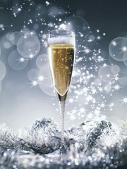 Champagne glass and silver decoration on silver shiny glitter background