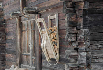 Wood carrier backpack hanging on old wooden wall in small village in swiss mountains
