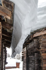 Obraz premium Snow covered old houses made of wood in alpine valley in Switzerland, Europe