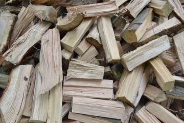 Closeup photograph of a pile of freshly cleaved firewood (oak and beech).