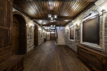 Corridor in mansion with stone walls and wooden doors