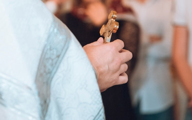 The priest is holding a cross