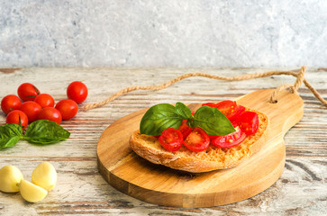 Fresh tomato bruschetta on wooden background, with basil and garlic