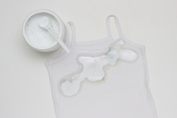 Children's white T-shirt with dirty spots, spots stained with stain remover, clothing and stain removal, white background, bleacher
