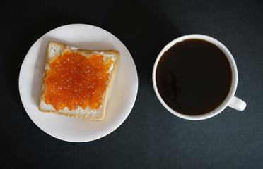 Sandwich with red caviar and coffee. Selective focus.