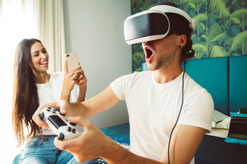 Virtual reality and wearable tech concept with young couple having fun together with headset goggles