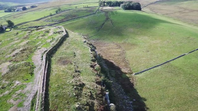 Aerial Hadrians Wall on cliff England Scotland border 4K. Hadrian's Wall a defensive fortification in the Roman province of Britannia built in AD122. Ancient tourist attractions.
