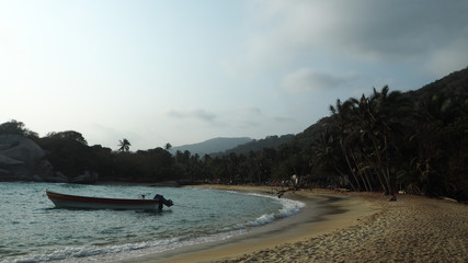 Obraz premium tropical beach with a boat at sunset in tayrona