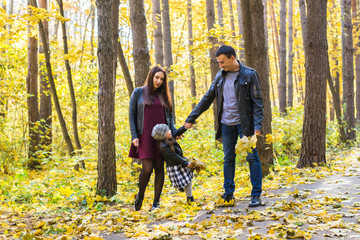 Obraz premium Parenthood, fall and people concept - young family happy in autumn park