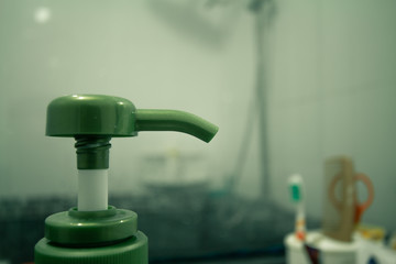 Green Pump head of liquid soap in the bathroom.
