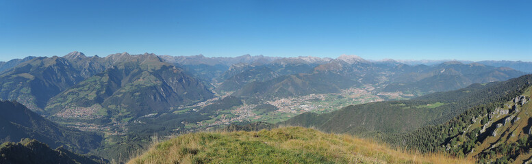 4K Drone aerial view to the Seriana valley and Orobie Alps in a clear and blue day. View of the highest mountains. Landscape from Pizzo Formico Mountain, Bergamo, Italy