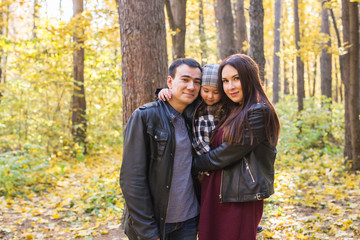 Fototapeta premium Fall, nature and family concept - happy family walking in autumn park
