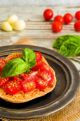 Fresh tomato bruschetta with fresh basil and garlic on rustic dish