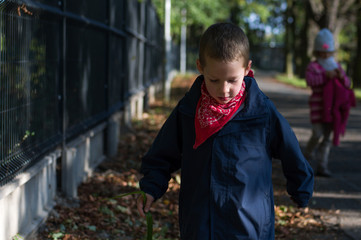 Fototapeta na wymiar Little boy with his sister in an autumn park