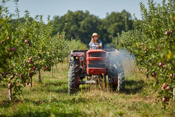 Young farmer woman driving her old tractor