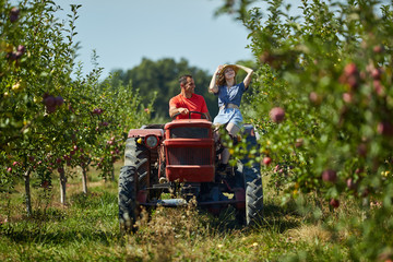 Farmers couple driving tractor