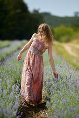 Obraz premium Farmer lady in floral dress in lavender field