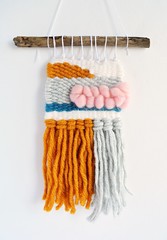 Colorful hand woven wall hanging over white