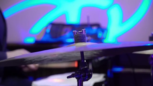 Man plays musical percussion instrument with sticks closeup on a concert stage, a musical concept with the working drum close up