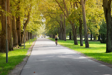 Women riding a bike in city park.