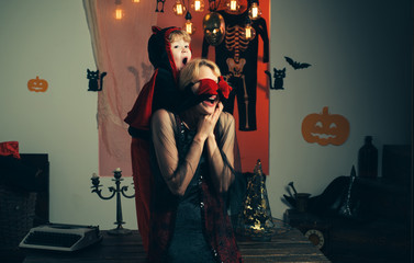 Mother wearing as witch, son wearing as devil. Family love and Halloween party. Best ideas for...