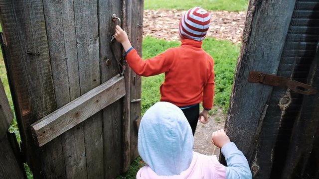 Little children open the old wooden door go for a walk on nature, slow motion
